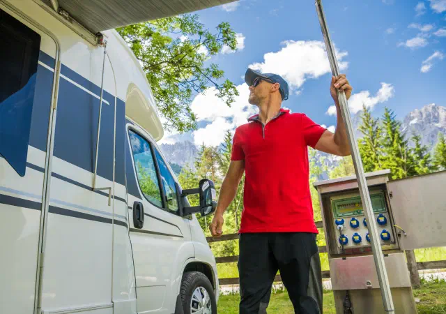 Man setting up an awning on an RV camper van